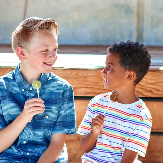 2 kids eating organic lollipops