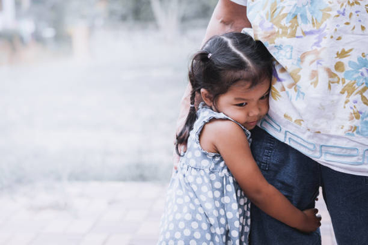 A child holding her parent looks nervous.