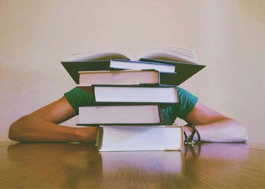 Person Behind Stack of Books