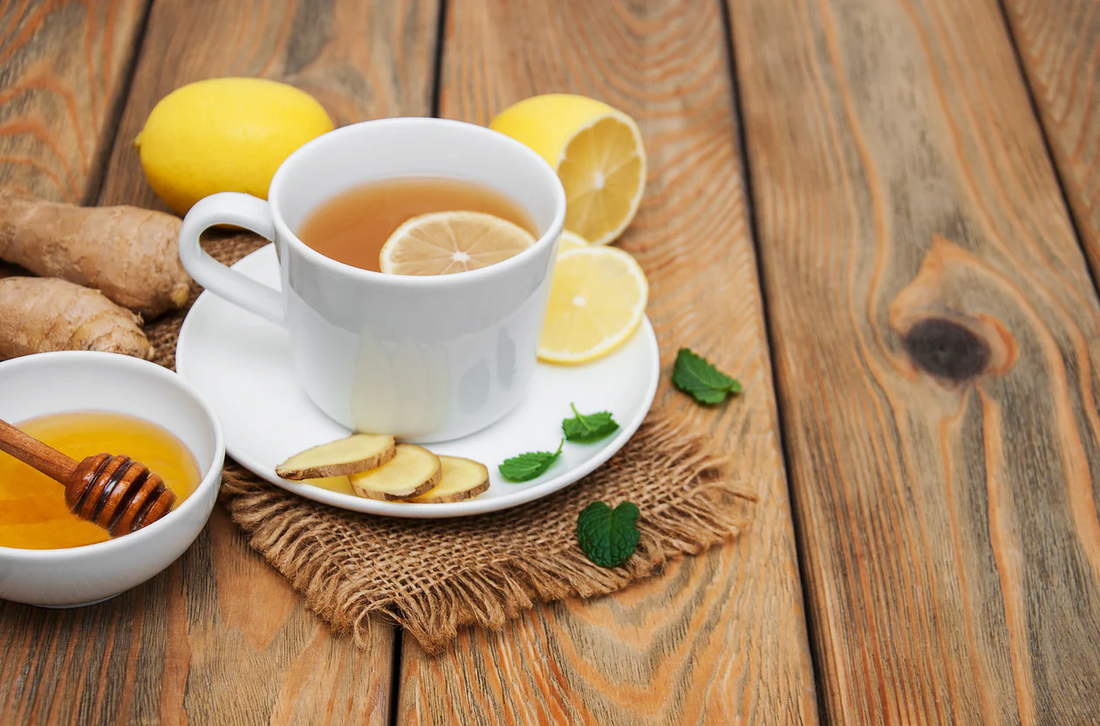 Tea with lemon, ginger, honey, and mint on a wooden table.