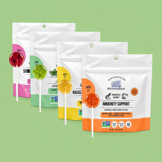 Four stand-up pouches of MommaBear herbal lollipops in different colors (red, green, yellow, orange) arranged in a row against a solid light green background.